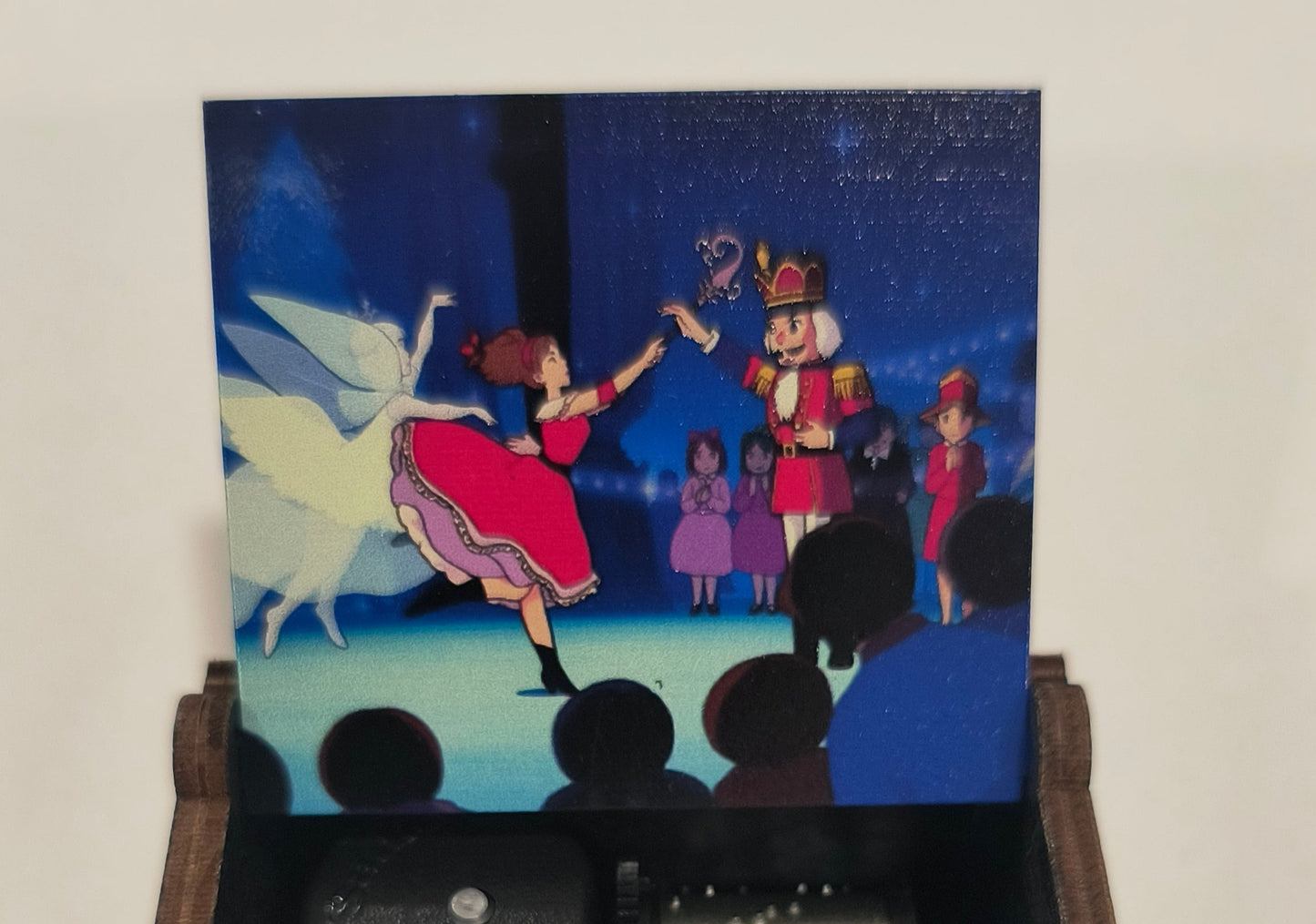 Hand holding a vintage-style camera with a small film reel, displaying a colorful image on a screen.