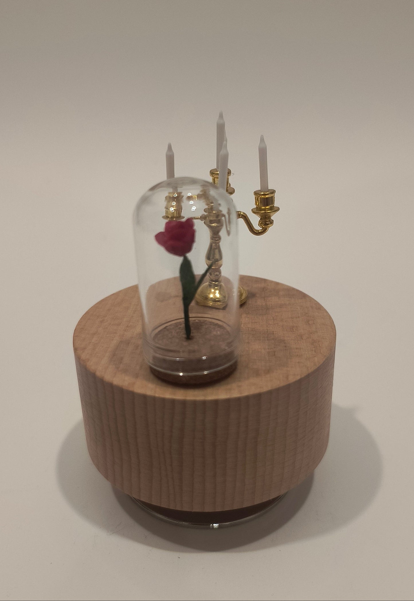 Wooden cylindrical clock with glass cover on a white background