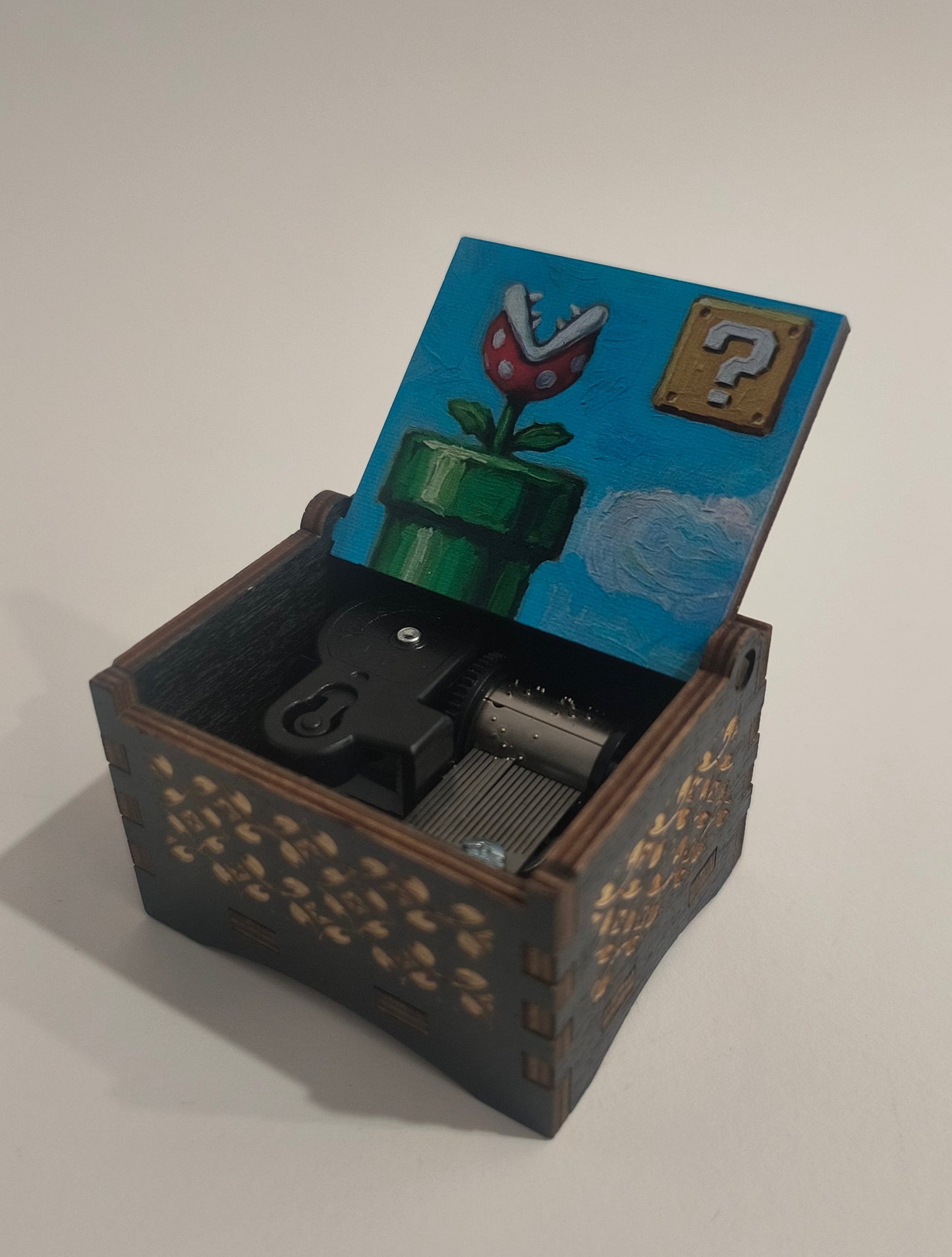 Small wooden box with a blue lid featuring a design, on a white background