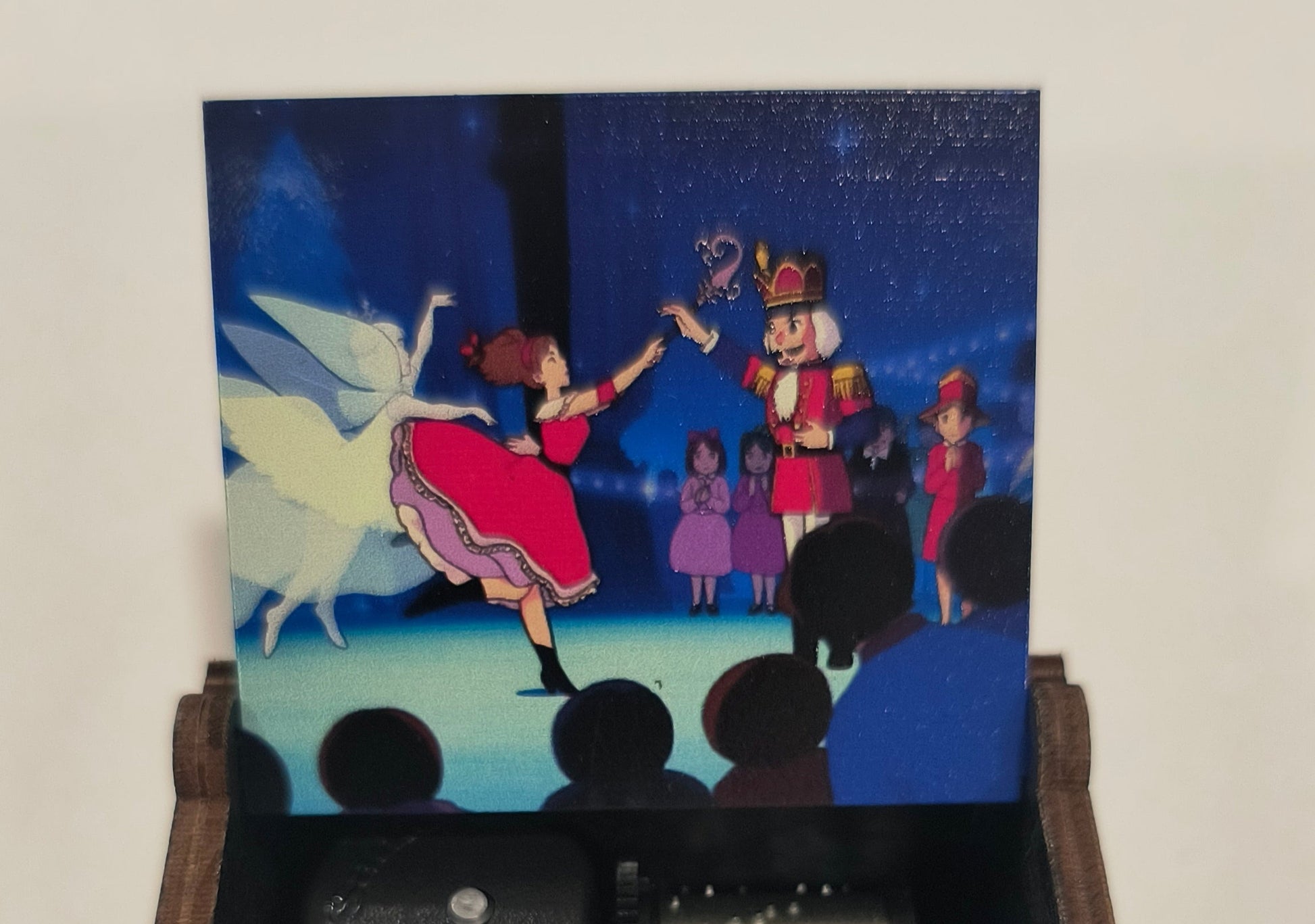 Hand holding a vintage-style camera with a small film reel, displaying a colorful image on a screen.