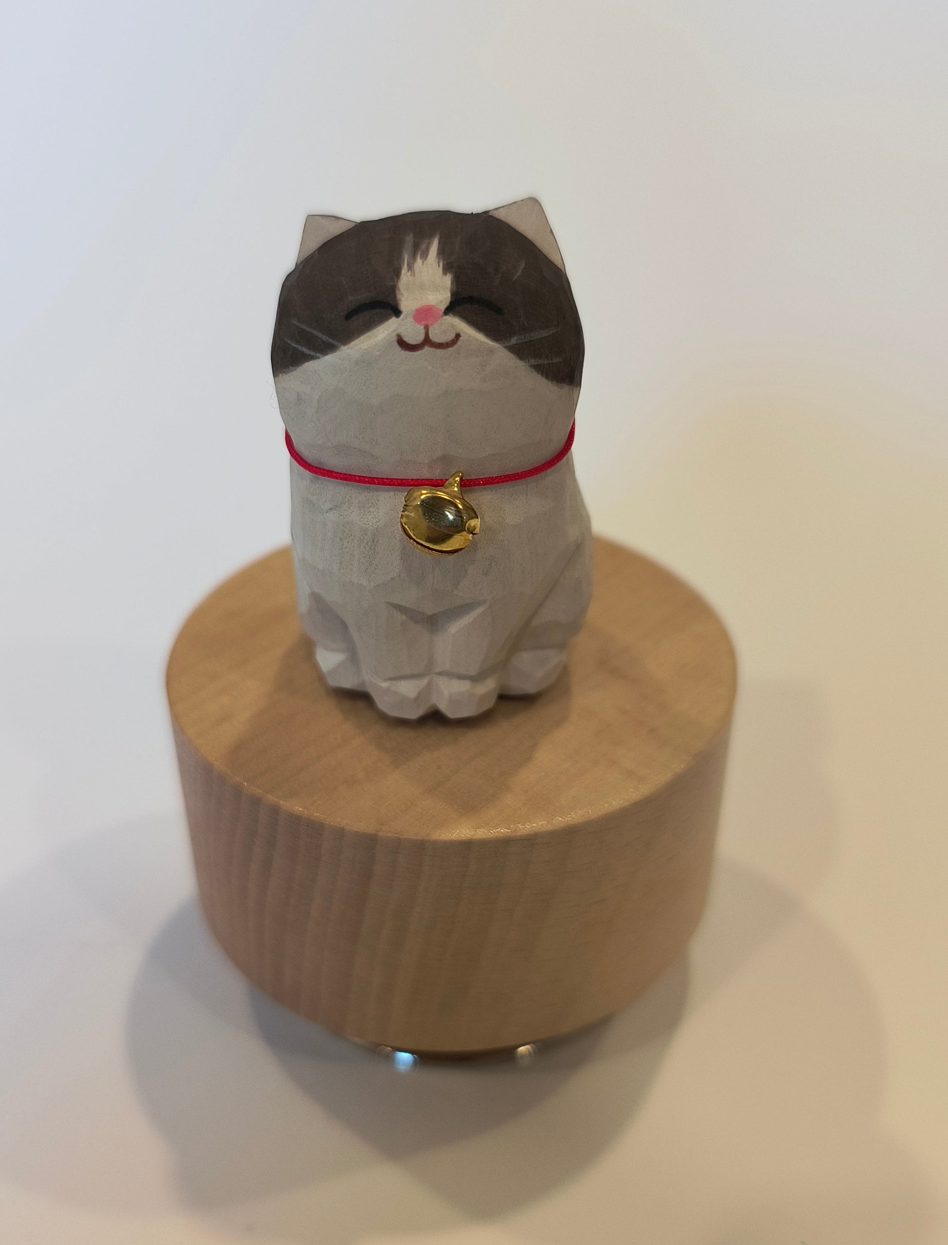 Wooden spindle with a cat-shaped top on a white background