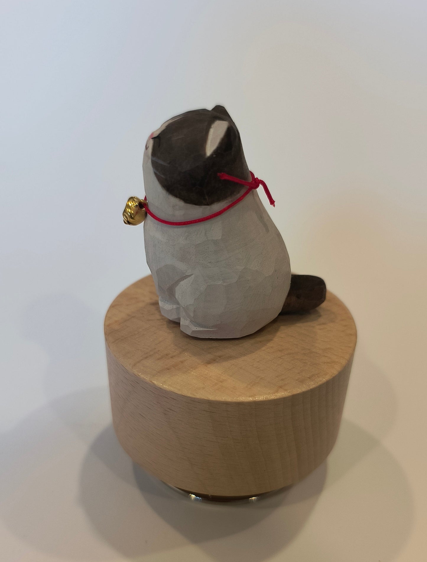 Cat toy with a plush cat figure and wooden base on a white background