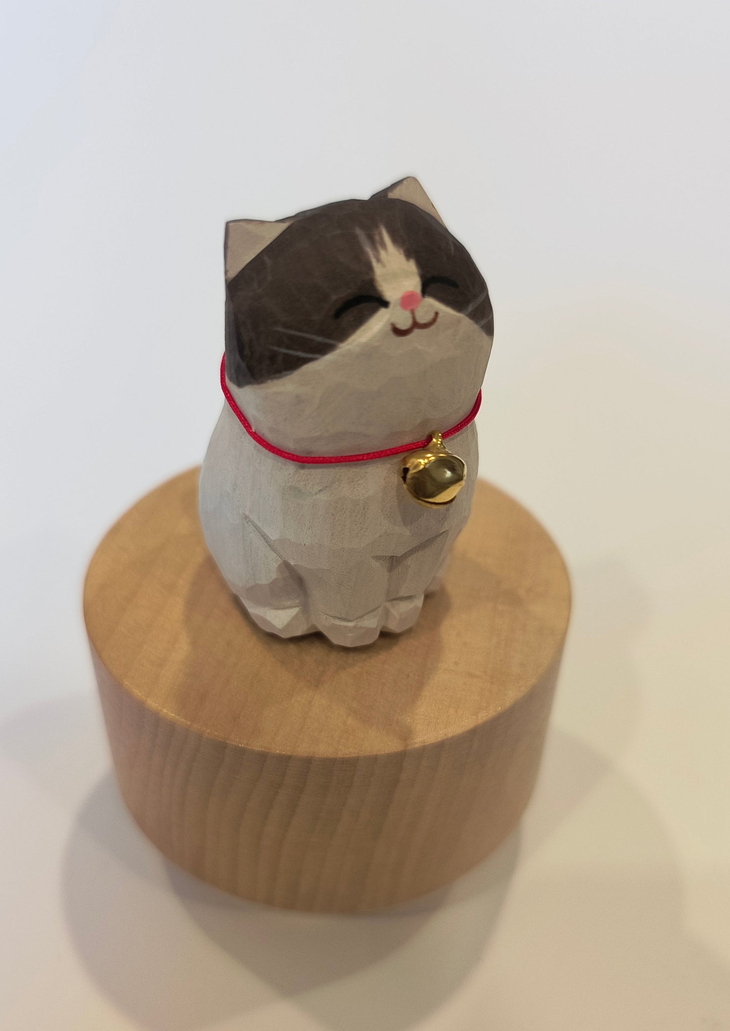 Cat-shaped doormat with a bell on a white background