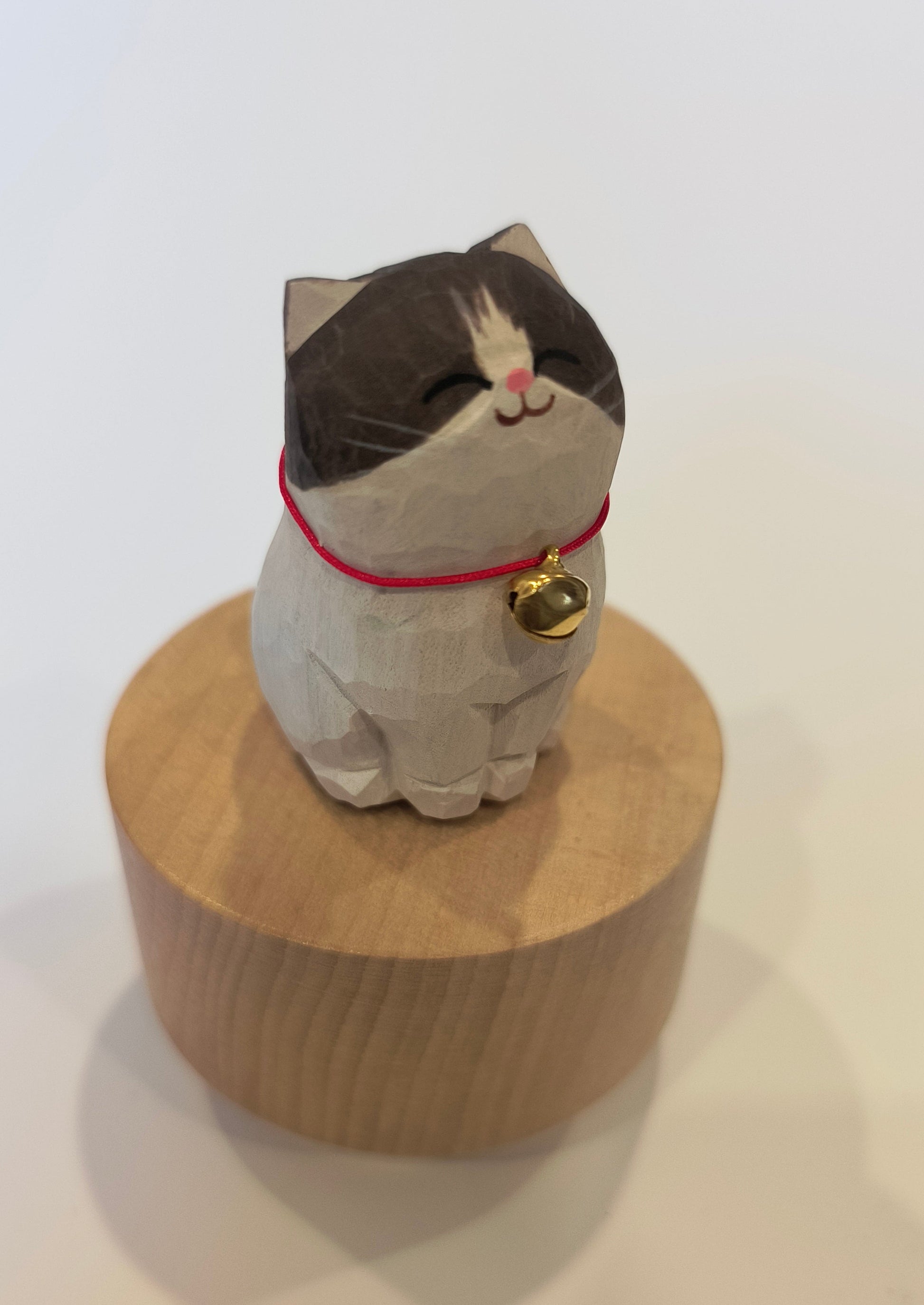 Cat-shaped doormat with a bell on a white background