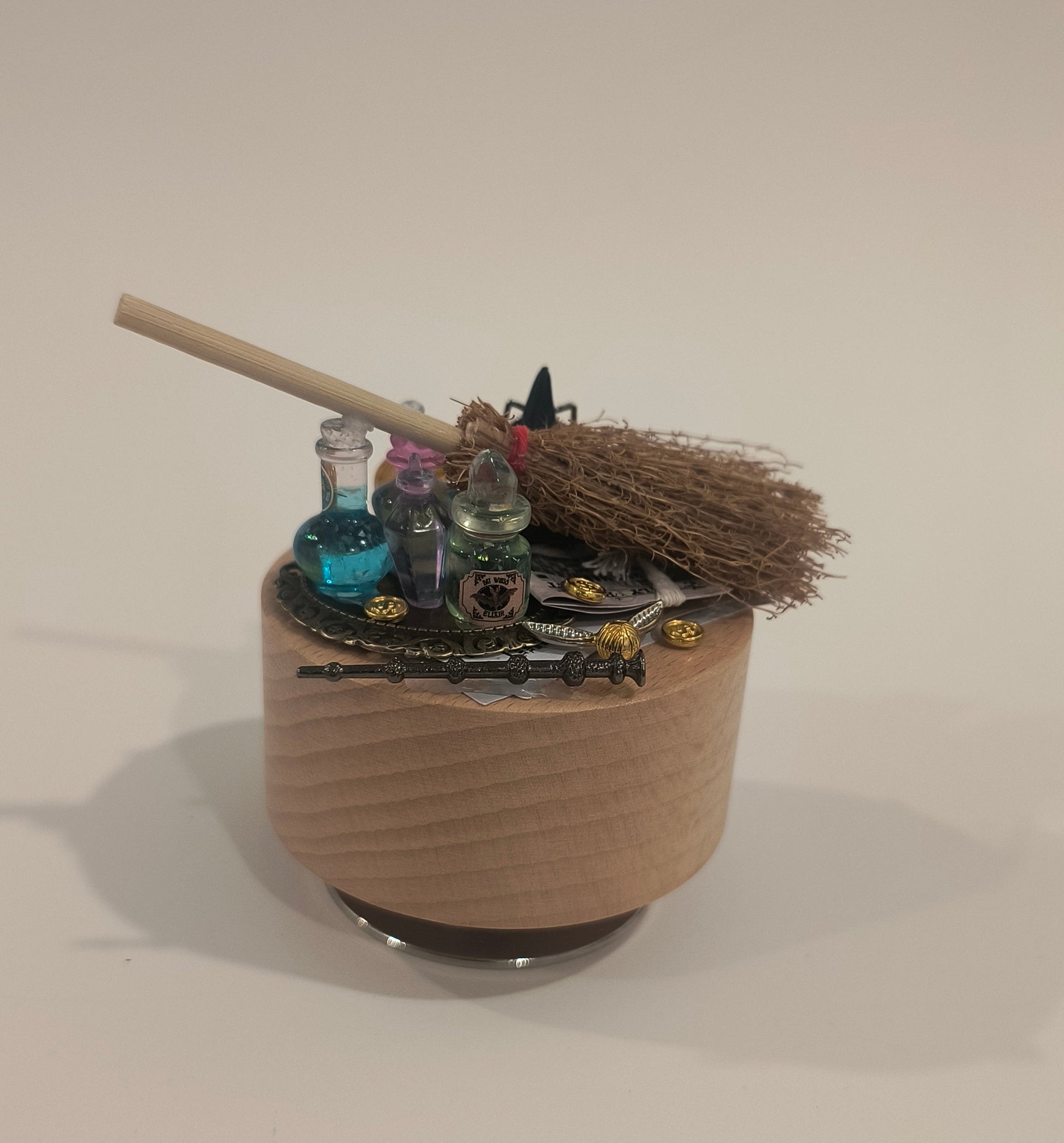 Decorative broom with a canister on a plain background