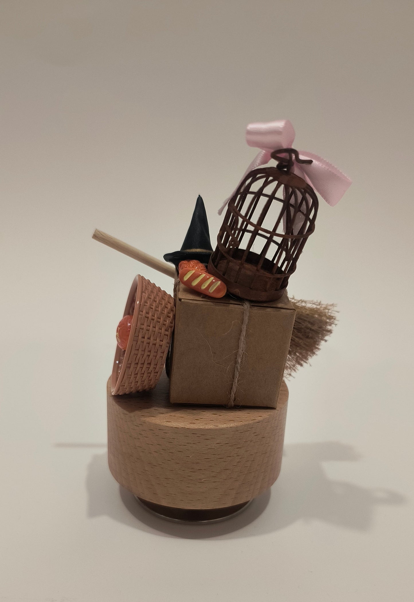 Cardboard sculpture of a character with a hat and a stick on a white wall