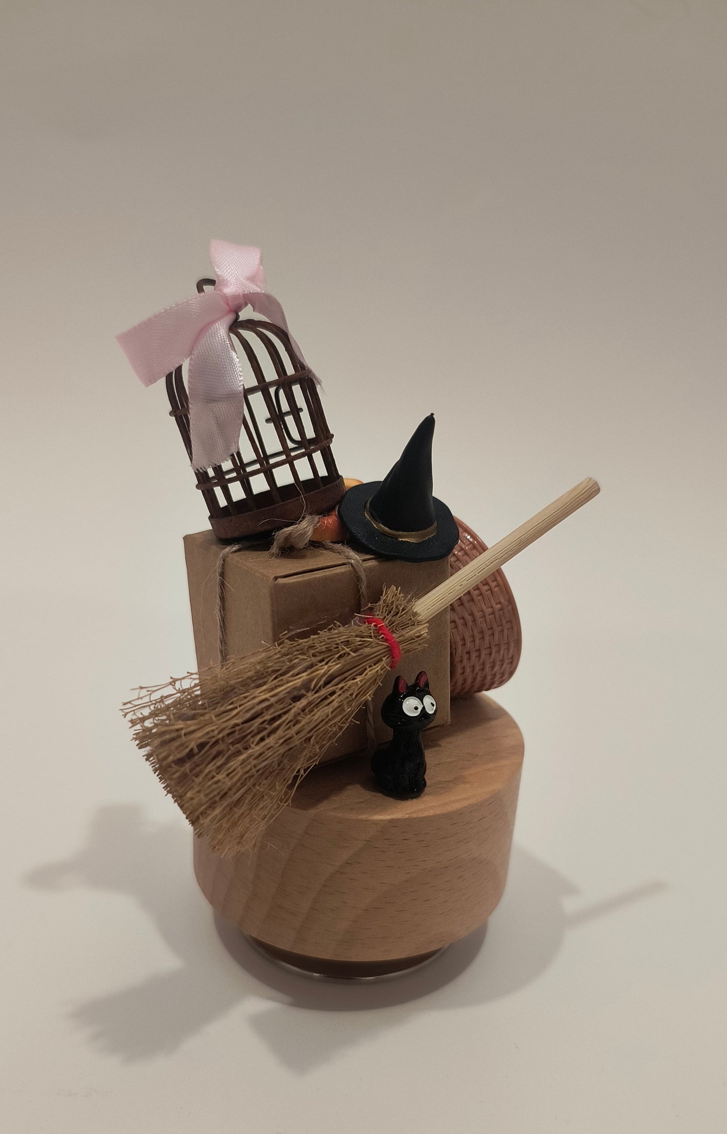 Decorative wall piece with a witch hat, broom, and black cat on a plain background