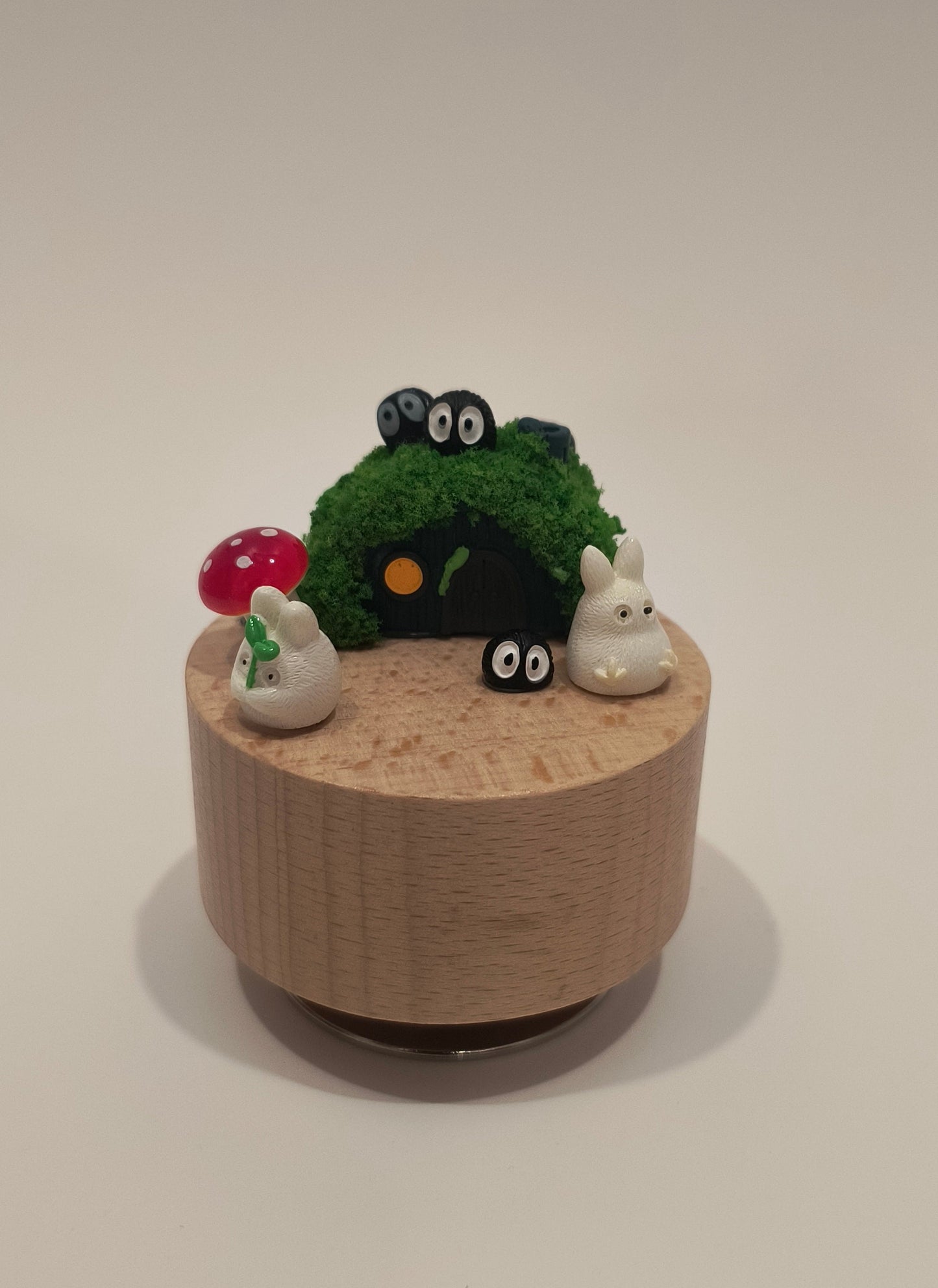 Decorative wall piece with a cylindrical base and green top on a plain background