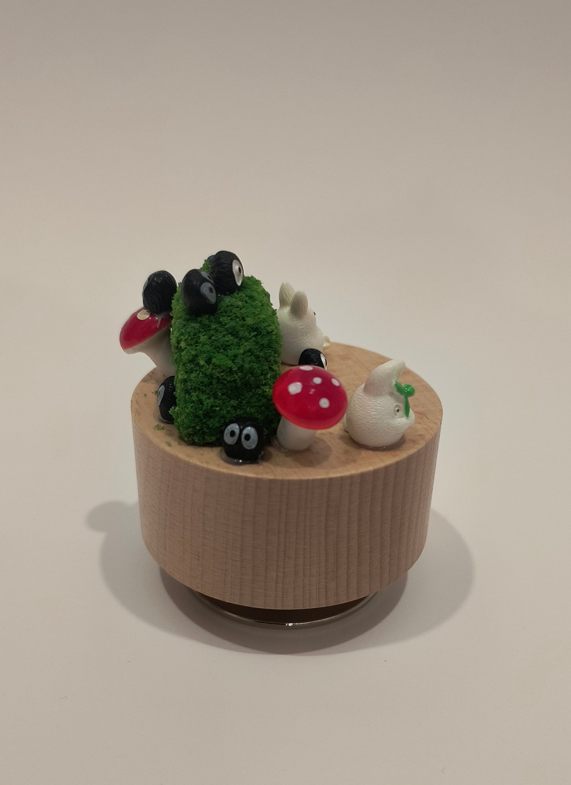 Small decorative pot with a green frog and red mushroom on a white background