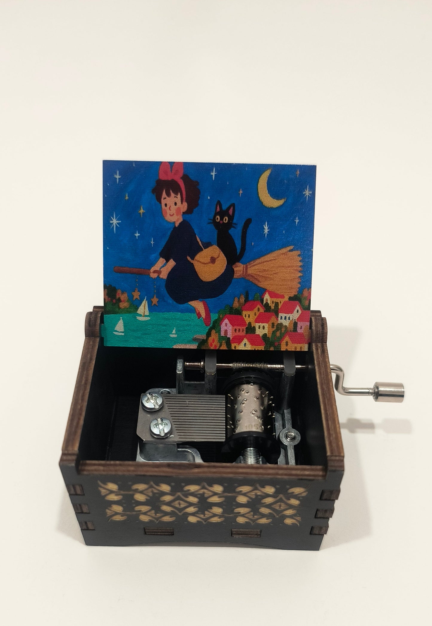 Wooden music box with a mechanical component and colorful illustration on a white background, kiki