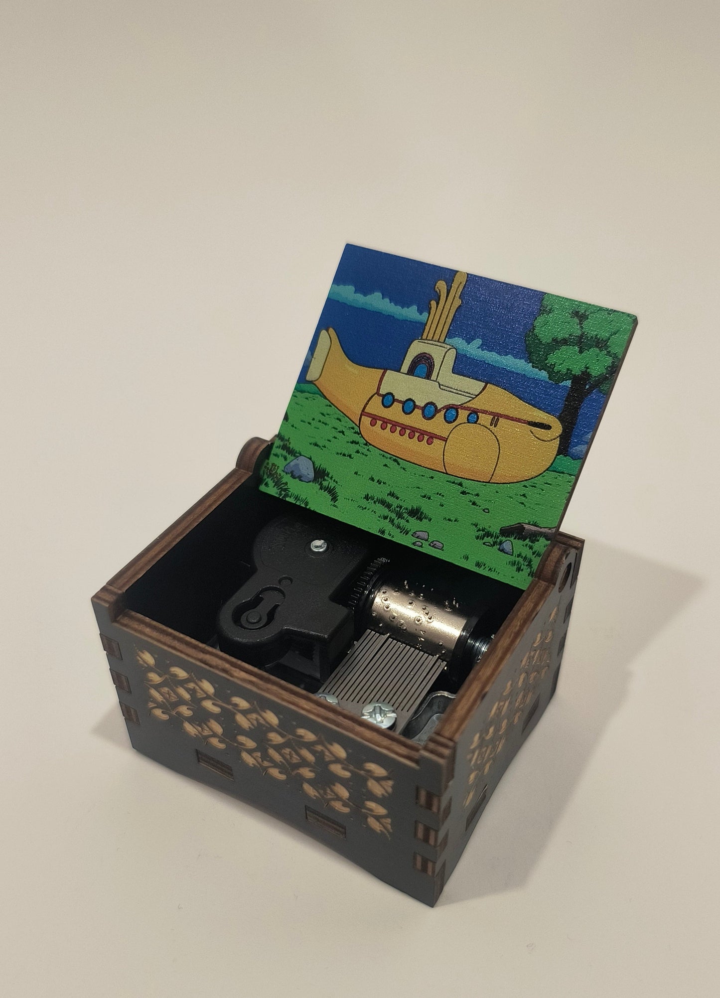 Small mechanical device with a colorful card featuring a submarine on a white background