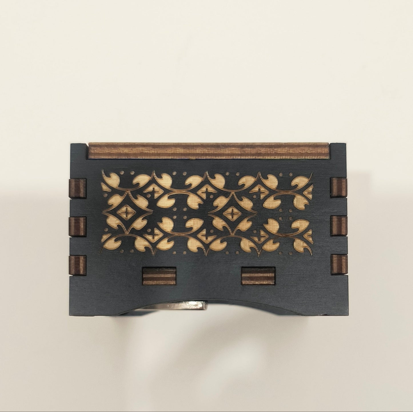 Decorative black box with floral patterns on a light beige background