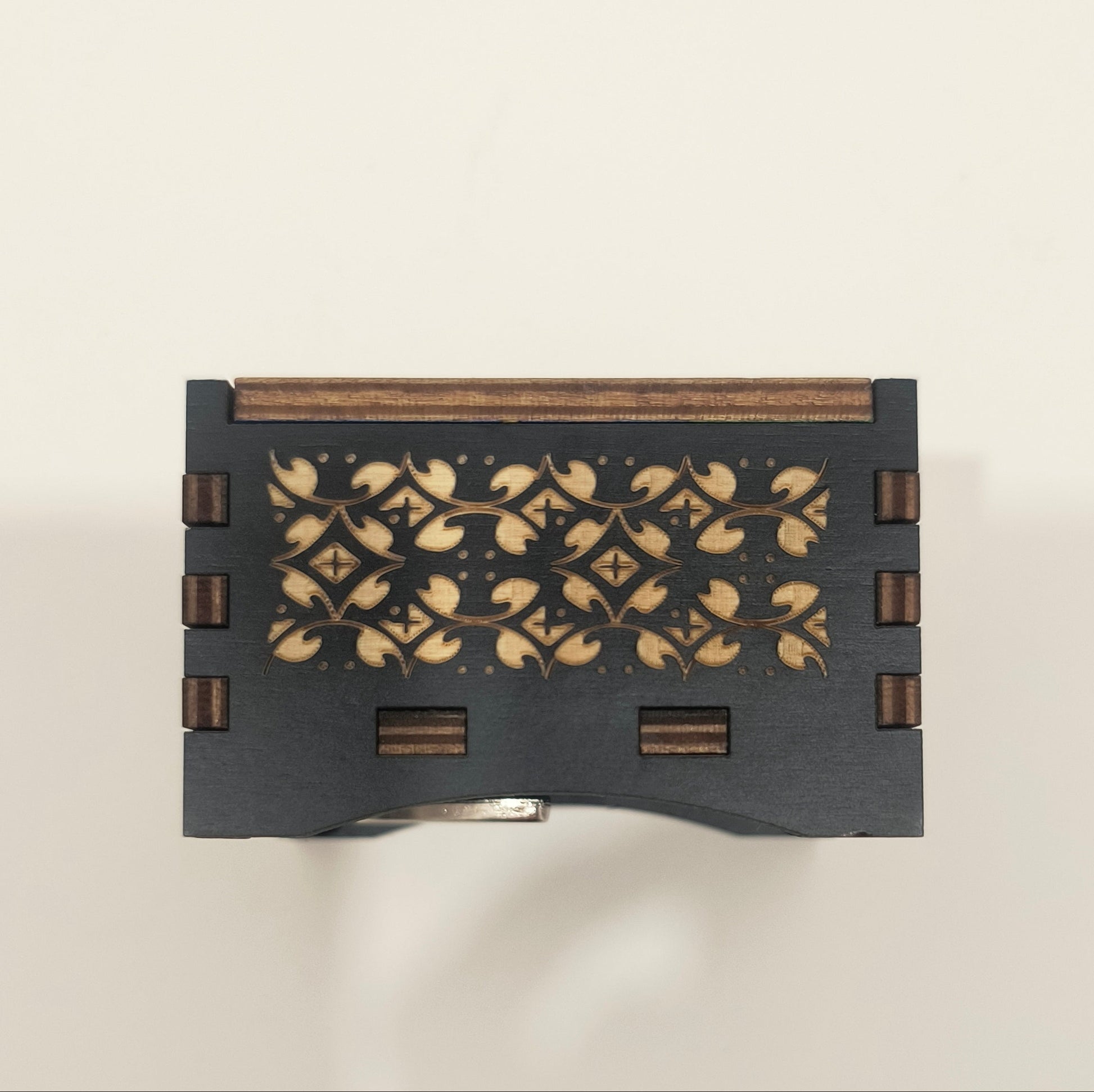 Decorative black box with floral patterns on a light beige background