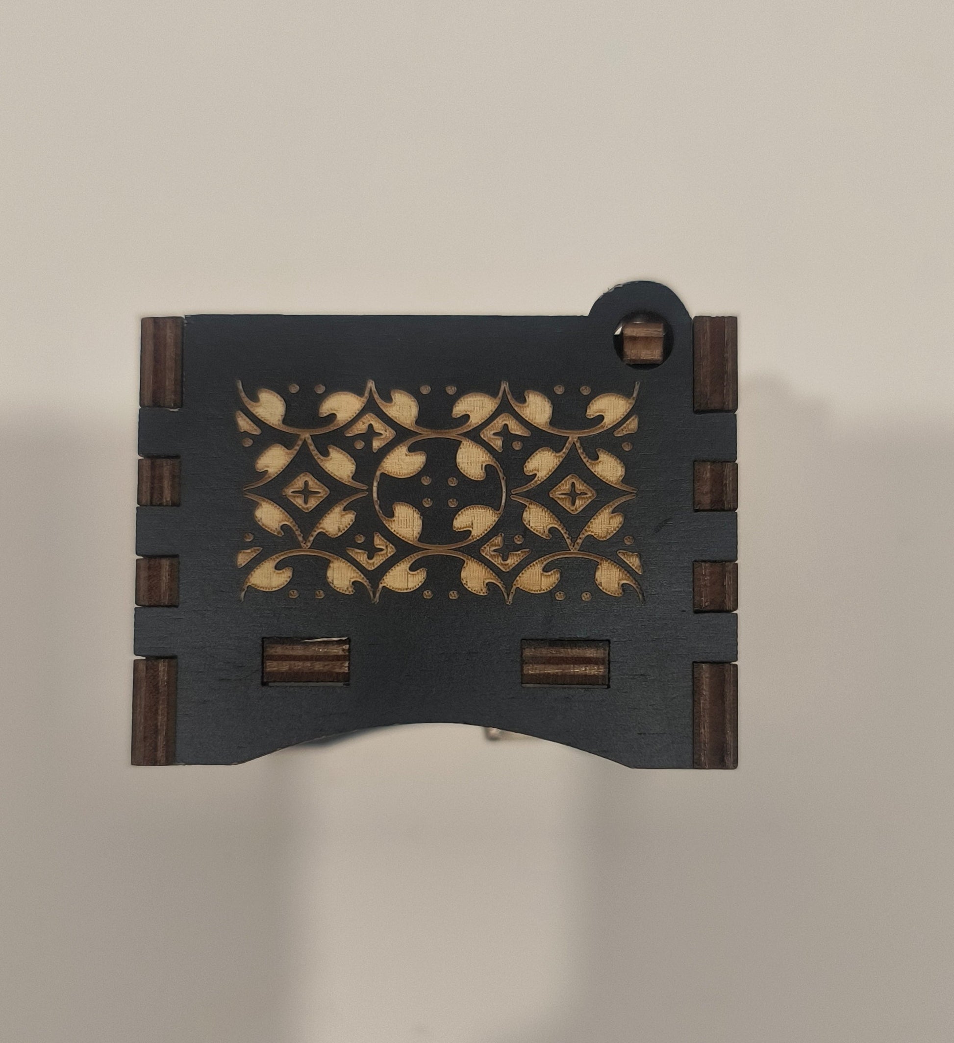 Decorative wooden box with intricate carvings on a neutral background