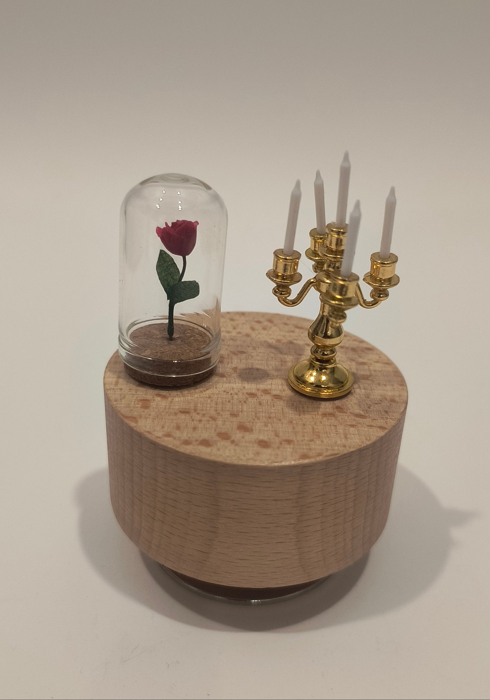 Decorative glass with floral design on a wooden stand against a plain background
