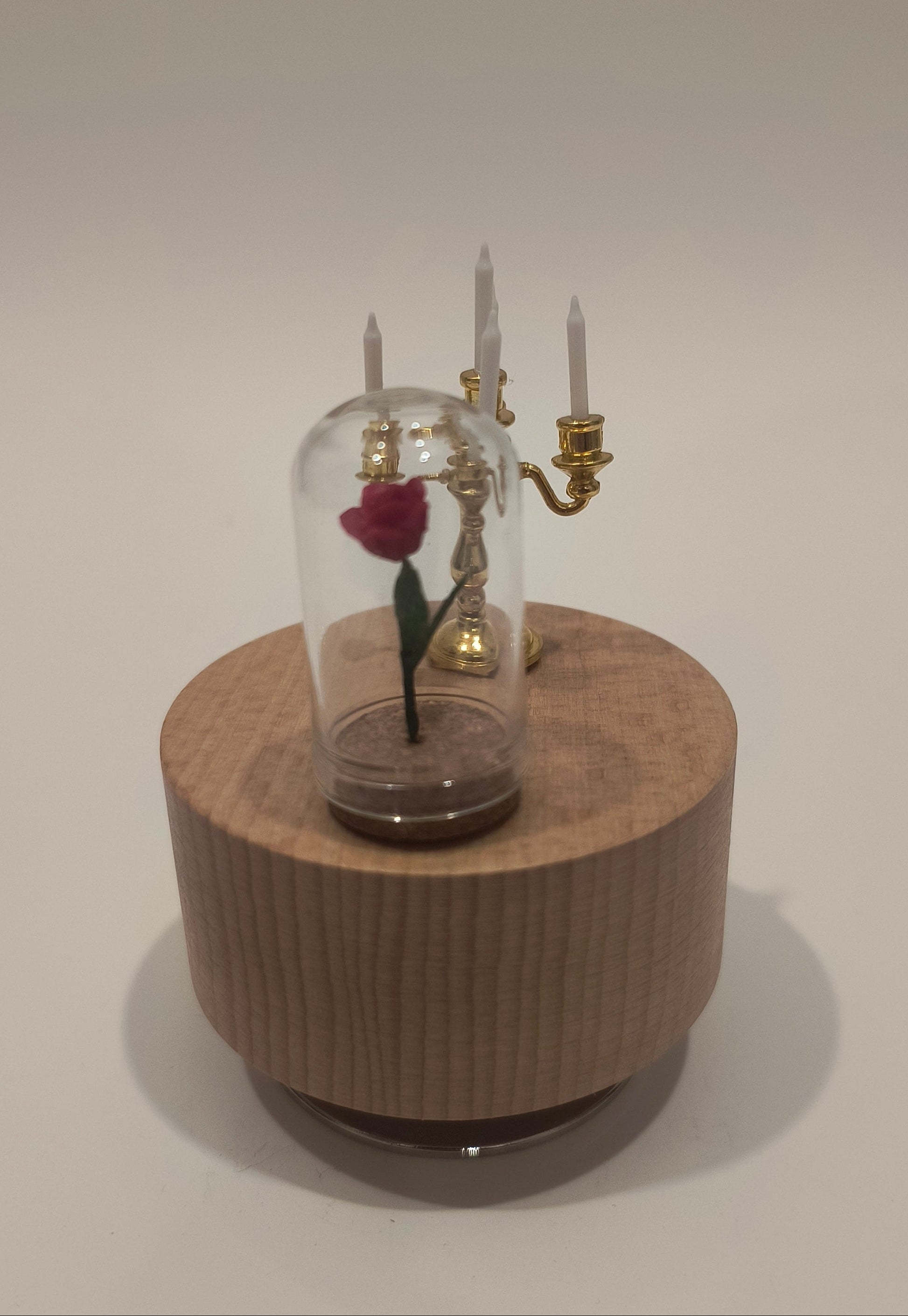 Wooden cylindrical clock with glass cover on a white background