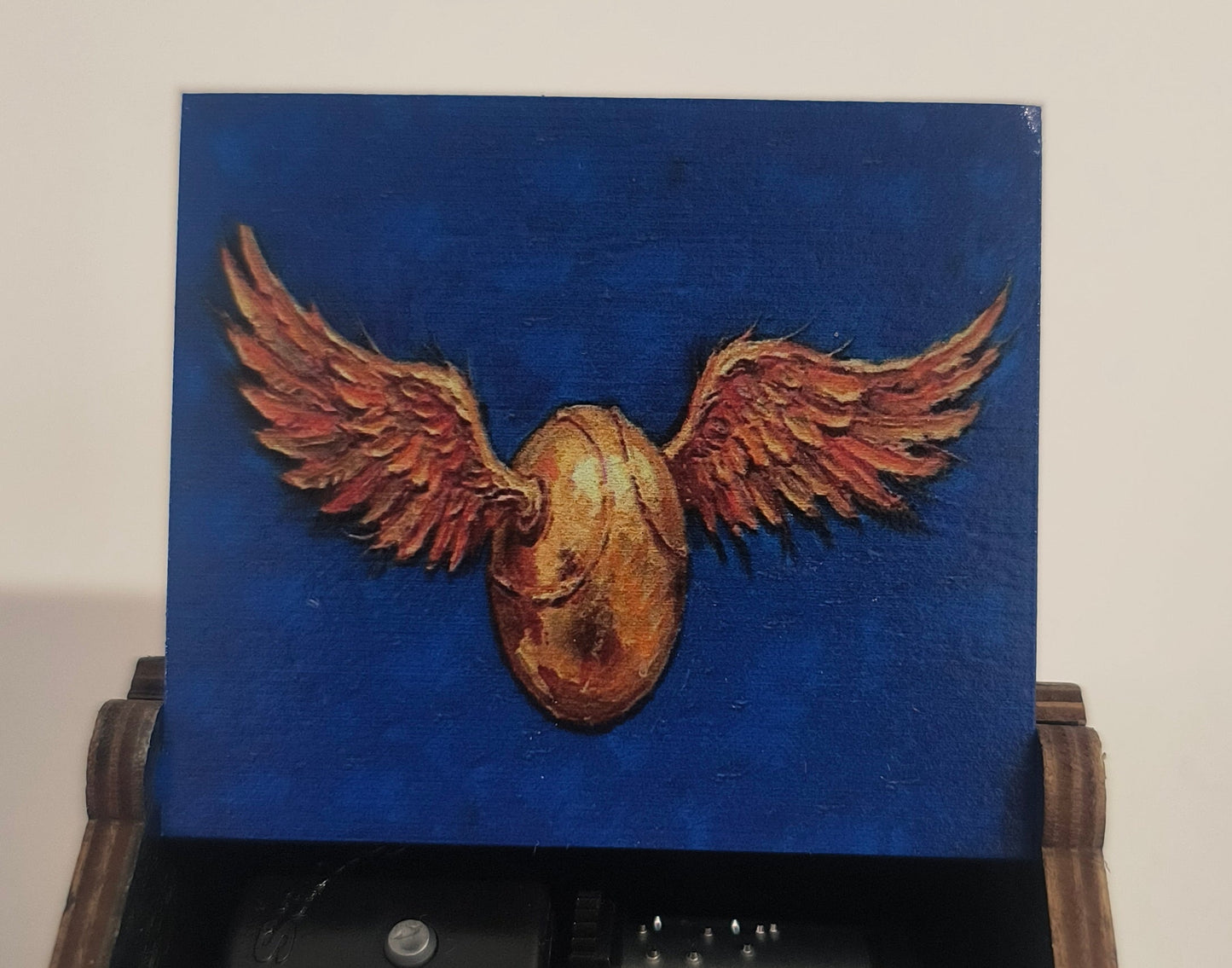 Wooden box with a mechanical eagle emblem on a blue background