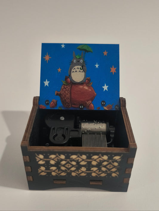 Decorative wall box with a cartoon character on a blue panel and intricate design on the side.