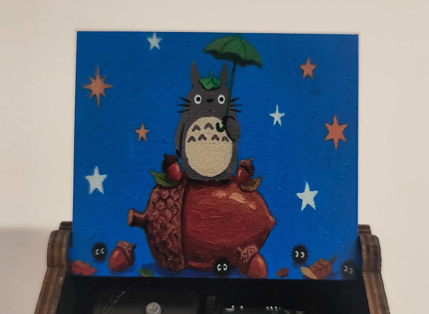 Wooden box with a mechanical interior and a colorful illustration on a blue background.