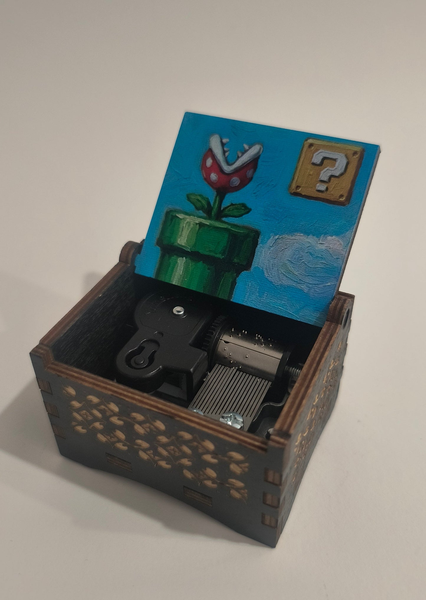 Small wooden box with a mechanical component on a white background